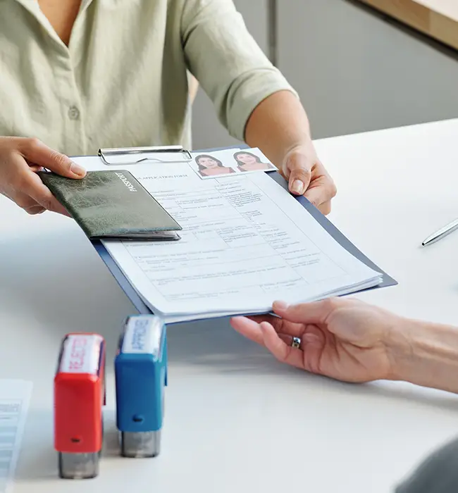 customer handing over the visa application form and passport to the staff